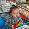 aisle, casual, child, clothing, cute, expression, face, food, hair, holding, indoor, person, plastic, product, retail, shelf, shopping_cart, supermarket, toddler, toy