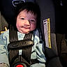 Sophia is registered to the contest to win money with this photo: baby, car_seat, child, infant, smile, harness, seatbelt, clothing, cute, face, person, indoors, sitting, safety, young_child, expression, portrait, light, warm_tone, closeup
