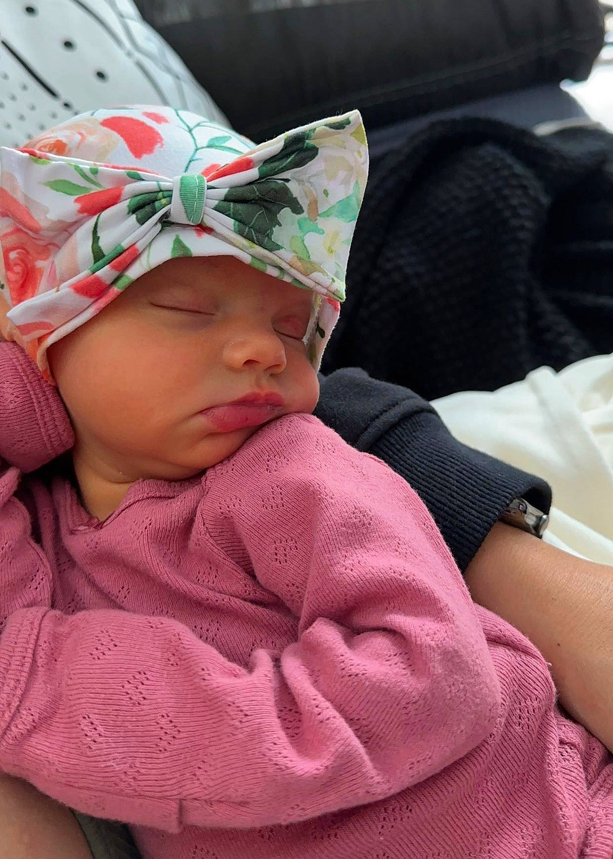 Fiona is registered to the contest to win money with this photo: baby, baby_carriage, baby_products, baby_toddler_clothing, beanie, cap, carmine, cheek, child, comfort, event, fashion_accessory, happy, headwear, linens, magenta, nap, person, pink, sitting