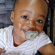 Serenity joined the competition — help win amazing prizes! toddler, child, baby, smiling, pacifier, hair_clips, stroller, face, portrait, skin, eyes, clothing, seatbelt, infant, cute, happy, person, indoors, mobile_phone_screen, app_icons