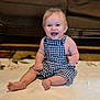 baby, child, smiling, sitting, romper, blue_checkered_clothing, barefoot, indoor, blanket, happy, face, person, cute, infant, home, furniture, carpet, young, portrait, cheerful