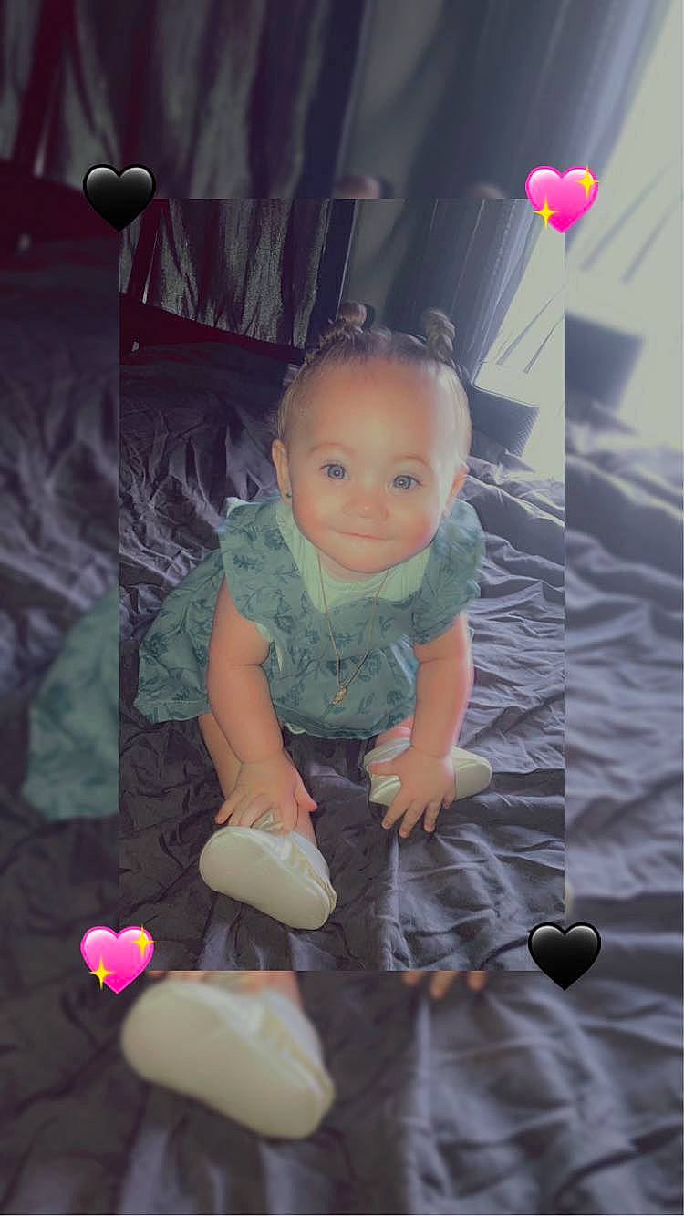 Liberty is registered to the contest to win money with this photo: baby, baby_toddler_clothing, cheek, child, flash_photography, flooring, foot, fun, hairstyle, happy, head, magenta, pattern, person, pink, purple, room, sitting, smile, t_shirt