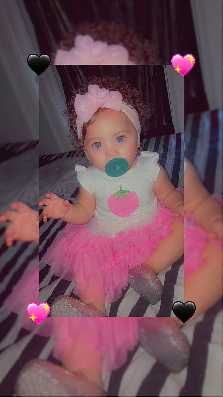 Liberty is registered to the contest to win money with this photo: arm, baby, baby_products, baby_toddler_clothing, chair, child, costume, doll, dress, event, happy, magenta, peach, person, petal, pink, room, sitting, stuffed_toy, textile