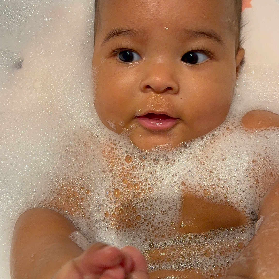 Liam is registered to the contest to win money with this photo: baby, bathing, bathtub, bodypart, bubble, face, finger, hand, head, newborn, person, photography, portrait, toe, tub, washing
