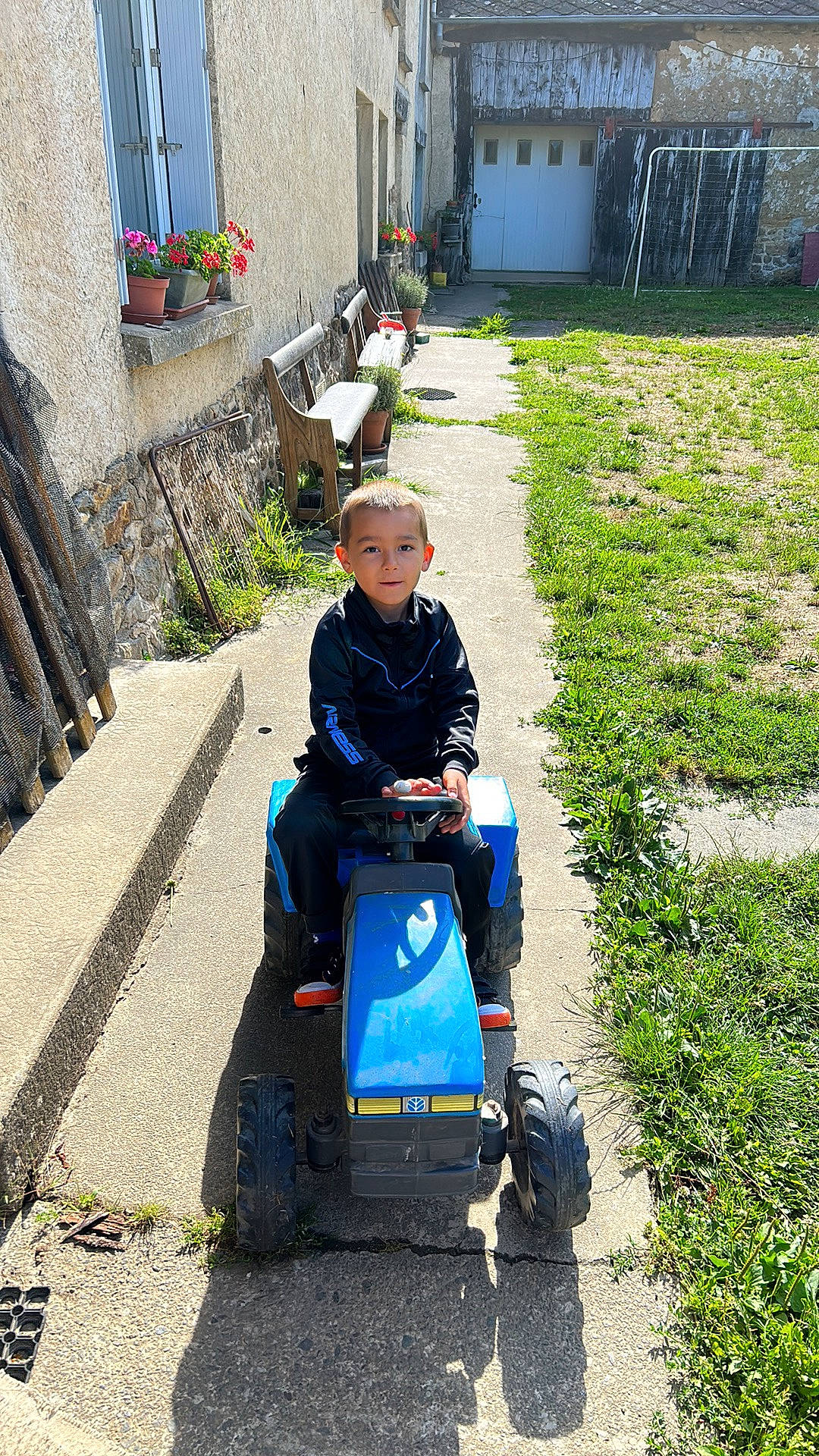 Noé participe au concours pour gagner de l'argent avec cette photo : asphalt, baby_carriage, building, door, grass, houseplant, lawn_mower, leisure, mower, person, plant, recreation, road, road_surface, rolling, sidewalk, tire, toddler, travel, wheel