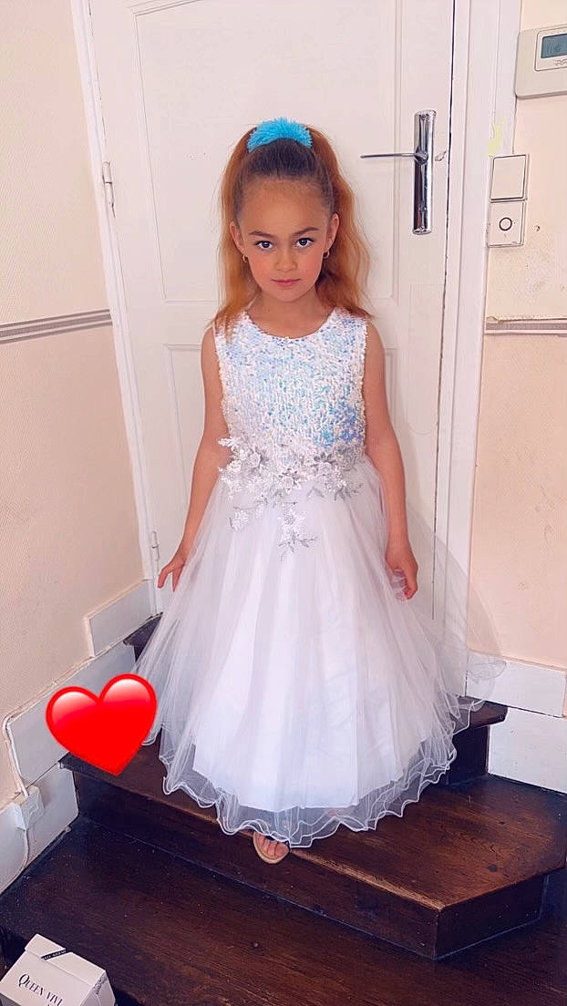 Milla a rejoint le concours — aidez-le/la à gagner de superbes lots ! arm, bridal_clothing, bridal_party_dress, day_dress, dress, embellishment, fashion_design, flooring, gown, hair, happy, human_body, neck, one_piece_garment, person, pink, sleeve, textile, waist, wedding_ceremony_supply