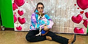 Linus joined the competition — help win amazing prizes! boots, brown_dog, casual_clothing, cross_legged, cute, decorations, dog, floor, floor_tile, glasses, heart_backdrop, indoor, indoor_lighting, matching_outfits, person, pet, playful_expression, posing, sitting, tie_dye_hoodie