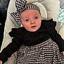 Sienna joined the competition — help win amazing prizes! baby, infant, headband, black_clothing, houndstooth_pattern, skirt, cushion, soft_fabric, blue_eyes, face, indoors, person, child, cute, portrait, sitting, comfortable, plush, closeup, apparel
