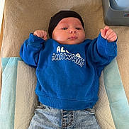 Khyronn participe au concours pour gagner de l'argent avec cette photo : baby, child, infant, blue_sweatshirt, black_hat, jeans, rolled_up_jeans, black_socks, changing_pad, baby_care_items, expression, lying_down, indoors, skin, face, hands, clothing, person, cute, casual