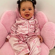 Taslim participe au concours pour gagner de l'argent avec cette photo : baby, child, pajamas, pink, chair, smile, happy, cute, indoor, pigtails, hair, feet, sitting, face, person, soft, plush, cozy, clothing, portrait