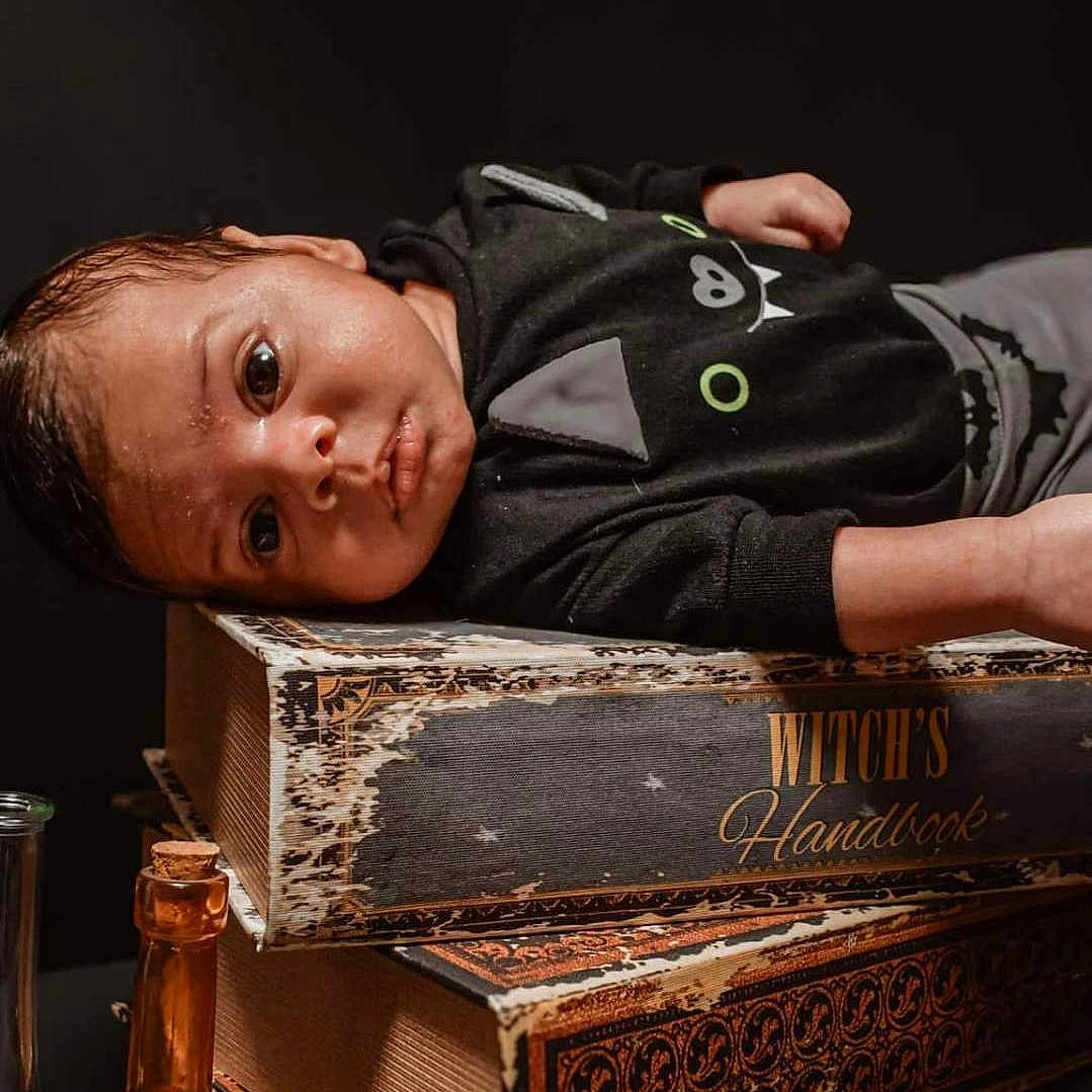 Nell is registered to the contest to win money with this photo: baby, bodypart, book, bottle, cosmetics, face, finger, hand, happy, hardwood, head, indoors, interiordesign, perfume, person, photography, portrait, publication, smile, wood