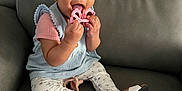 Maylee is registered to the contest to win money with this photo: baby, child, smiling, toy, headband, leggings, sitting, couch, footwear, sandals, happy, indoor, person, clothing, accessory, face, hand, cute, playful, infant