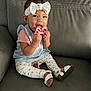 baby, child, smiling, toy, headband, leggings, sitting, couch, footwear, sandals, happy, indoor, person, clothing, accessory, face, hand, cute, playful, infant