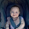arm, baby, bib, blue_eyes, child, childcare, closeup, cute, face, hand, happy, head, infant, padded_stroller, pink_clothing, portrait, seatbelt, sitting, smile, stroller