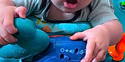 Melyo participe au concours pour gagner de l'argent avec cette photo : baby, child, infant, toy, activity_center, blue, play, curious, indoor, floor, colorful, plastic, hand, face, expression, closeup, seat, crawling, person, young