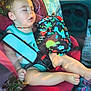 child, toddler, sleeping, car_seat, toy, dinosaur_pattern, seatbelt, reflection, window, car_interior, summer, outdoor_reflection, baby, clothing, peaceful, nap, legs, hand, head, seat