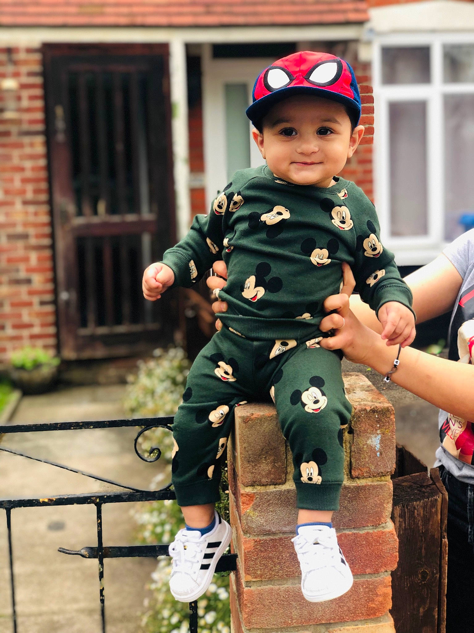 Andrei is registered to the contest to win money with this photo: baseball_cap, boot, brick, brickwork, cap, child, fun, gesture, grass, happy, headgear, headwear, joy, leisure, military_person, military_uniform, person, personal_protective_equipment, recreation, sitting