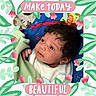 baby, infant, blanket, face, curly_hair, blue_clothing, green_blanket, floral_frame, pink_banners, text_overlay, looking_up, cute, portrait, indoors, child, young, person, expression, soft_lighting, colorful