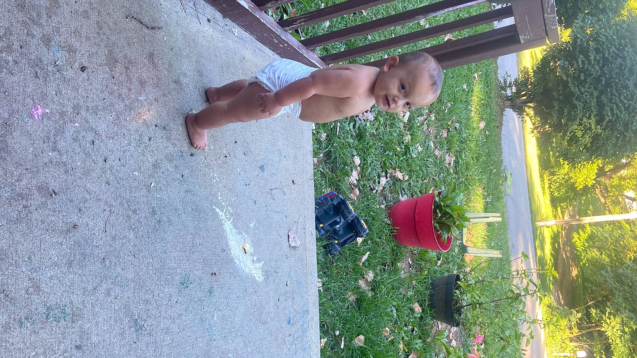 Atticus is registered to the contest to win money with this photo: barechested, concrete, elbow, foot, fun, grass, human_leg, knee, leisure, light, line, people_in_nature, person, plant, play, recreation, shadow, shorts, thigh, toddler