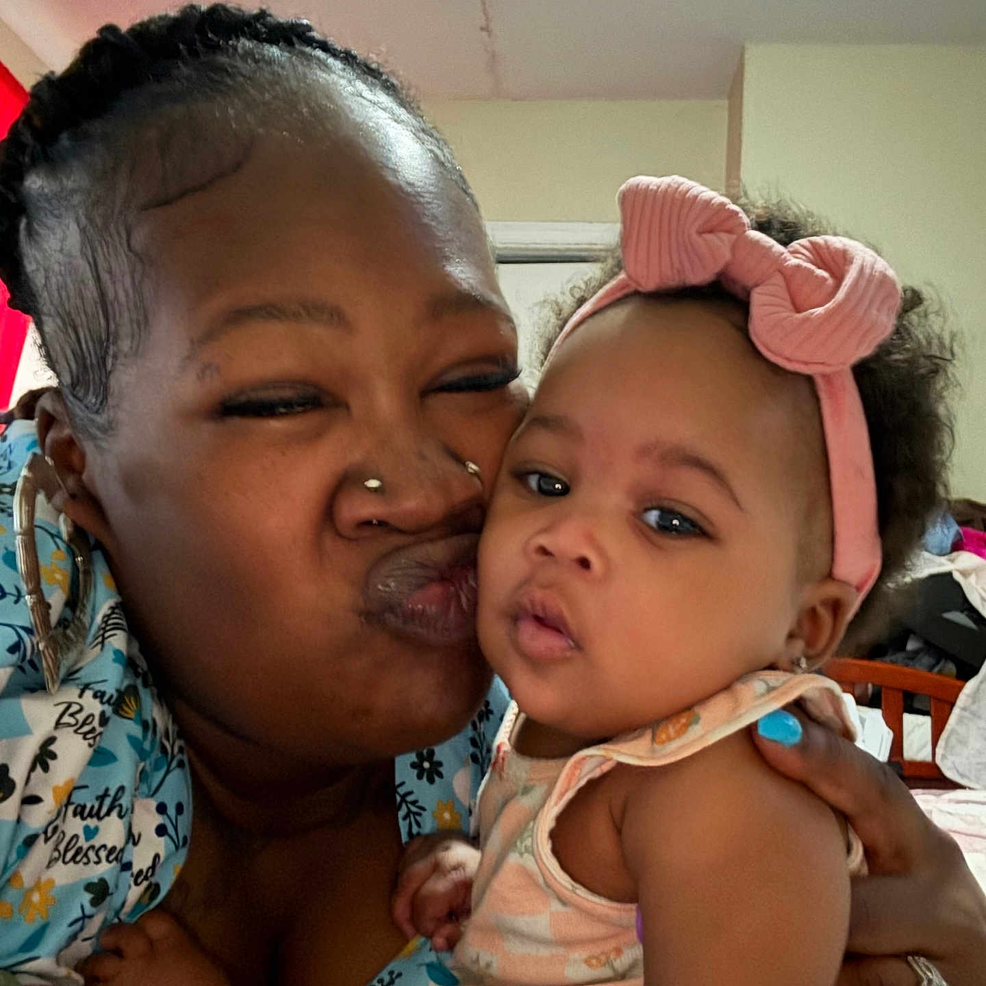 Leonna is registered to the contest to win money with this photo: woman, baby, child, face, headband, kiss, affection, indoor, portrait, holding, curly_hair, clothing, earrings, happy, family, skin, person, closeup, expression, love