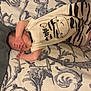 baby, sleeping, infant, bed, blanket, clothing, pattern, hand, foot, face, skin, cute, zebra, striped, lying_down, resting, peaceful, indoor, soft, comfort