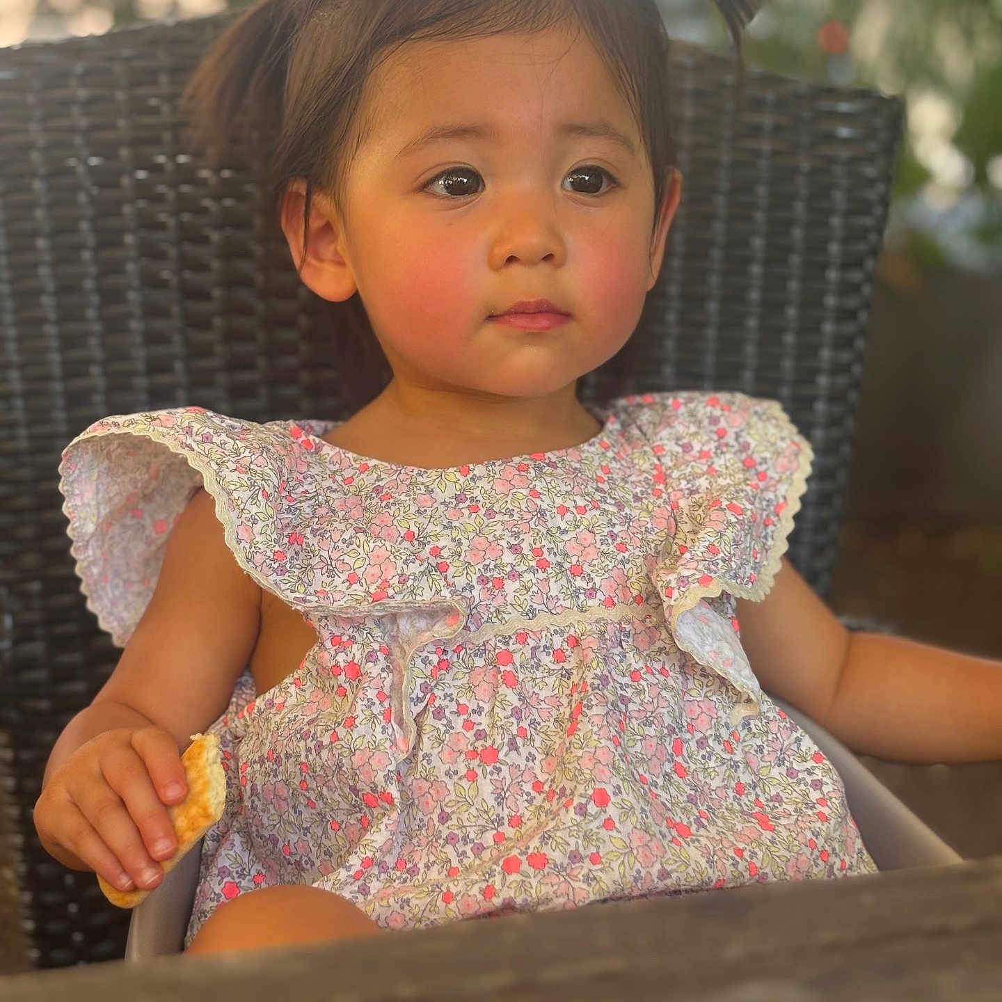 Mia participe au concours pour gagner de l'argent avec cette photo : child, cracker, cute, daylight, expression, floral_dress, girl, hair, outdoor, pigtails, portrait, rosy_cheeks, sitting, skin, soft_focus, summer, table, toddler, wicker_chair, young_child