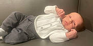 Kayden joined the competition — help win amazing prizes! baby, infant, person, clothing, pants, shirt, couch, furniture, face, head, skin, newborn, young_child, indoor, resting, lying, small, cute, hands, expression