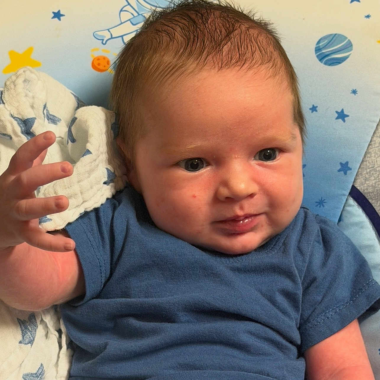 Robert joined the competition — help win amazing prizes! baby, infant, child, blue_shirt, blanket, stars, space_theme, seat, hand, face, expression, hair, skin, indoors, comfort, cute, young, portrait, clothing, resting