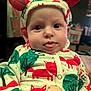 baby, child, hoodie, clothing, red_ears, fox_pattern, tree_pattern, tongue_out, face, eyes, indoor, blurred_background, cute, infant, apparel, pacifier_clip, portrait, expression, soft_lighting, close_up