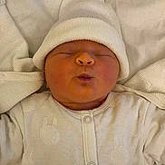 Isïs a rejoint le concours — aidez-le/la à gagner de superbes lots ! newborn, baby, infant, sleeping, white_clothing, hat, blanket, pajamas, cozy, cute, soft, face, portrait, child, bundle, resting, indoors, warm, tiny, peaceful