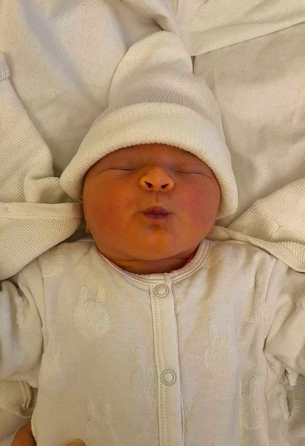 Isïs a rejoint le concours — aidez-le/la à gagner de superbes lots ! newborn, baby, infant, sleeping, white_clothing, hat, blanket, pajamas, cozy, cute, soft, face, portrait, child, bundle, resting, indoors, warm, tiny, peaceful