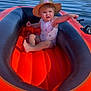 baby, calm, child, daylight, inflatable_boat, lake, nature, outdoor, pointing, recreation, river, sitting, sky, summer, sunhat, swimsuit, toddler, trees, water, water_sports