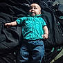 Jayson is registered to the contest to win money with this photo: baby, bed, blanket, blue_jeans, casual, child, clothing, curious_expression, cute, footwear_absent, home, indoor, infant, lying_down, person, portrait, relaxed, soft_lighting, turquoise_shirt, young_child