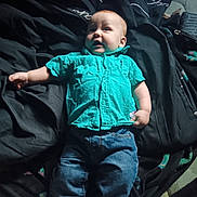 Jayson joined the competition — help win amazing prizes! baby, blanket, blue_jeans, casual_clothing, child, curious_expression, face, footwear_absent, head, indoor, infant, lying_down, natural_light, person, relaxed_pose, skin, small_hands, soft_fabric, turquoise_shirt, young_child