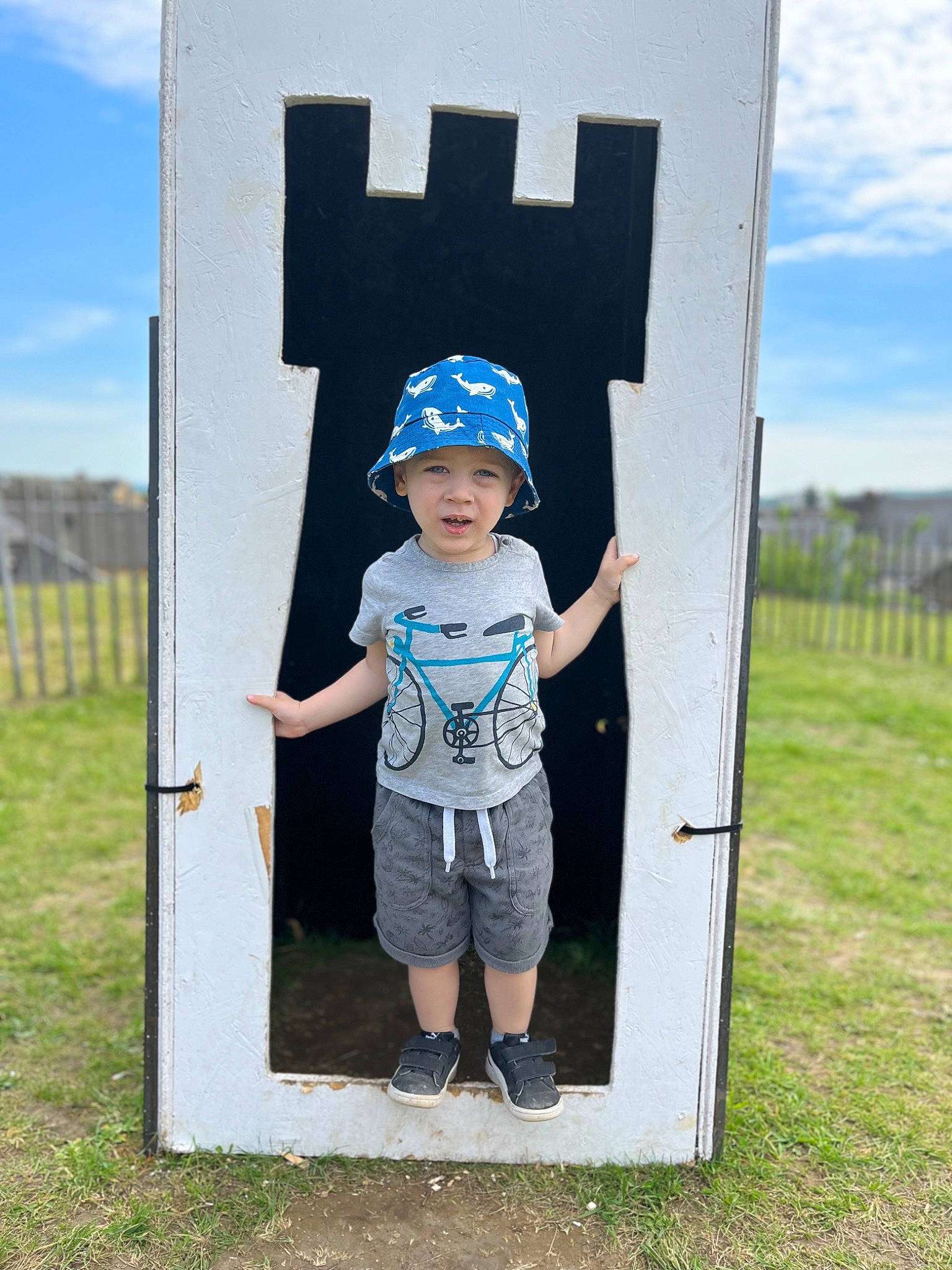 Elliott a rejoint le concours — aidez-le/la à gagner de superbes lots ! art, child, cloud, electric_blue, eyewear, fence, fun, grass, grassland, happy, headwear, leisure, pattern, people_in_nature, person, recreation, shorts, sky, standing, t_shirt