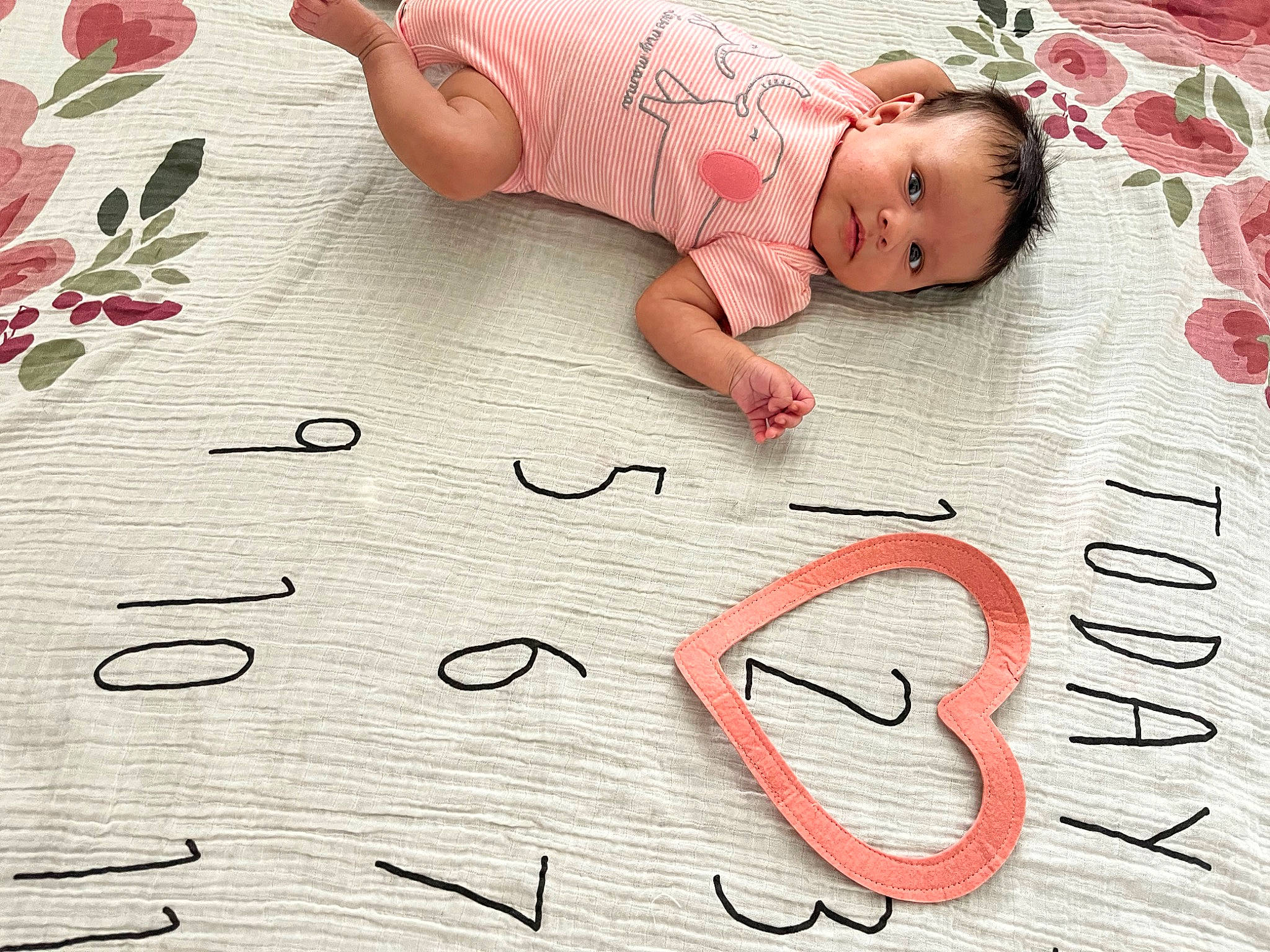 Kailani is registered to the contest to win money with this photo: baby, baby_toddler_clothing, child, comfort, design, facial_expression, finger, flooring, flower, font, hand, handwriting, happy, linens, nail, pattern, person, skin, textile, toddler