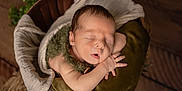 Arès a rejoint le concours — aidez-le/la à gagner de superbes lots ! newborn, baby, infant, sleeping, basket, blanket, pillow, cozy, portrait, studio, soft, cute, peaceful, small_hands, swaddle, wood_floor, greenery, top_view, props, newborn_photography