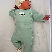 Arès a rejoint le concours — aidez-le/la à gagner de superbes lots ! baby, newborn, infant, hat, onesie, socks, cat_motif, mint_color, white_sheet, lying_down, portrait, looking_up, buttoned_clothing, hand, legs, soft_texture, cozy, cute, nursery, face