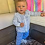 Meylan participe au concours pour gagner de l'argent avec cette photo : toddler, child, boy, standing, indoor, carpet, jeans, shirt, sneakers, face, hair, couch, bag, rug, furniture, person, clothing, home, cute, expression