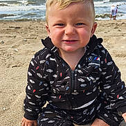 Meylan participe au concours pour gagner de l'argent avec cette photo : child, toddler, beach, sand, ocean, waves, smile, black_clothing, bmw_motorsport, sitting, happy, blond_hair, blue_eyes, casual_wear, outdoor, daylight, person, water, nature, playful