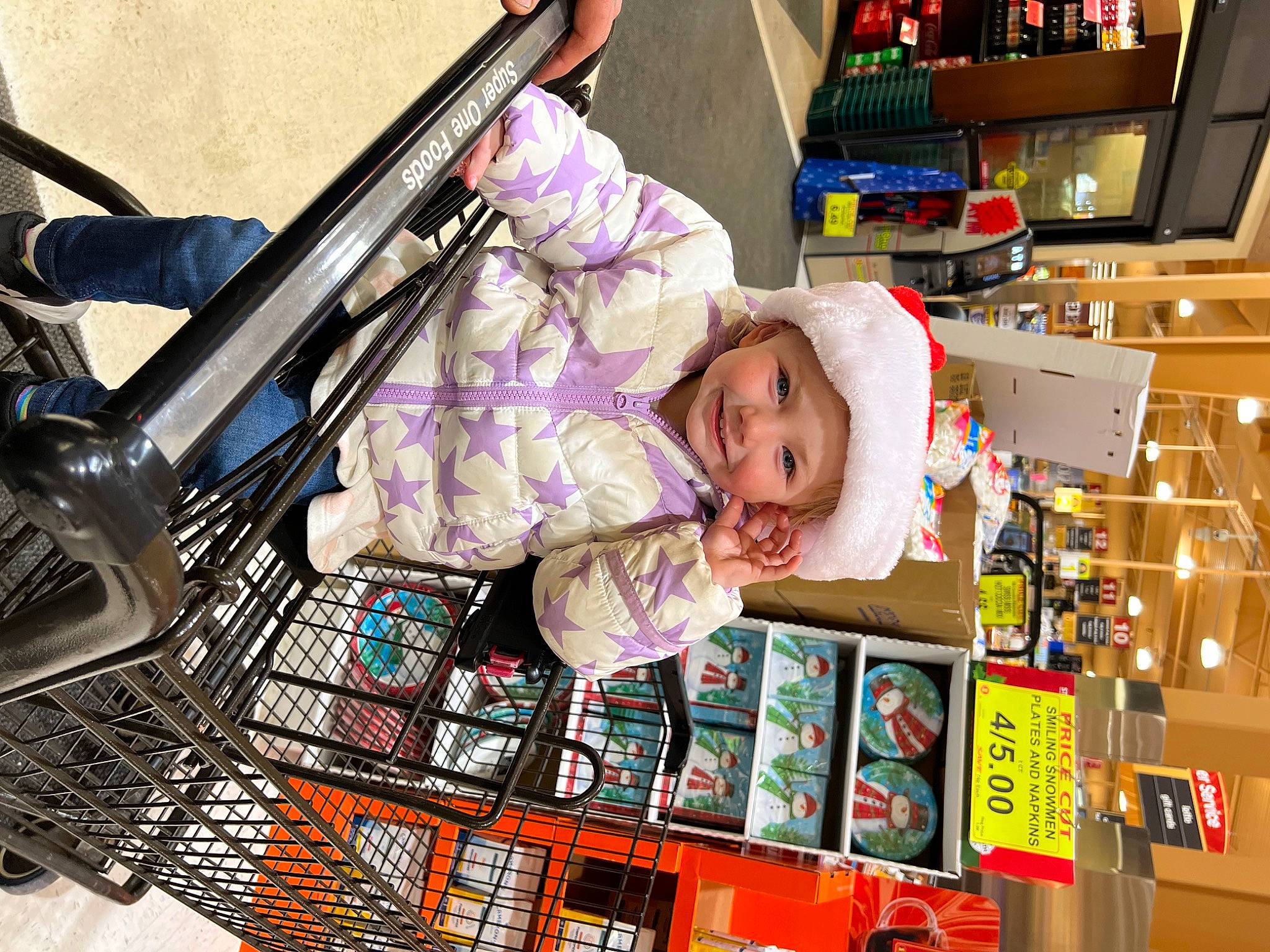 Barbara is registered to the contest to win money with this photo: baby, child, city, convenience_store, customer, fun, hat, headwear, joy, person, product, publication, retail, room, shelf, shelving, shopping, toddler, toy