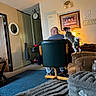 carpet, chair, clock, collar, couch, desk, dog, door, furniture, home, indoor, lamp, man, mirror, painting, person, pet, room, sweater, wall
