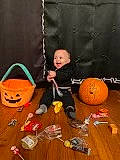 Asher is registered to the contest to win money with this photo: ball, calabaza, child, flooring, fun, happy, hardwood, leisure, orange, person, play, playground, pumpkin, recreation, sitting, smile, toddler, trick_or_treat, winter_squash, wood