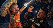 Hermes is registered to the contest to win money with this photo: baby, pacifier, owl, police_officer, night, full_moon, magic, light_beam, forest, tattoo, orange_outfit, smiling, action, fantasy, animal_attack, defense, man, outdoor, dramatic_lighting, funny