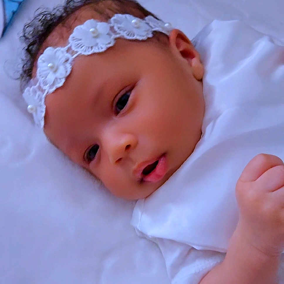 Nyvelle is registered to the contest to win money with this photo: baby, infant, headband, flower, pearl, white_clothing, sleeping_surface, soft_texture, cute, newborn, portrait, child, face, hand, skin, young, lying_down, indoors, closeup, peaceful