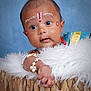 baby, infant, face_paint, jewelry, bracelet, basket, blanket, blue_background, cute, curious, portrait, closeup, child, traditional, cultural, soft_texture, fluffy, decorative, head, expression