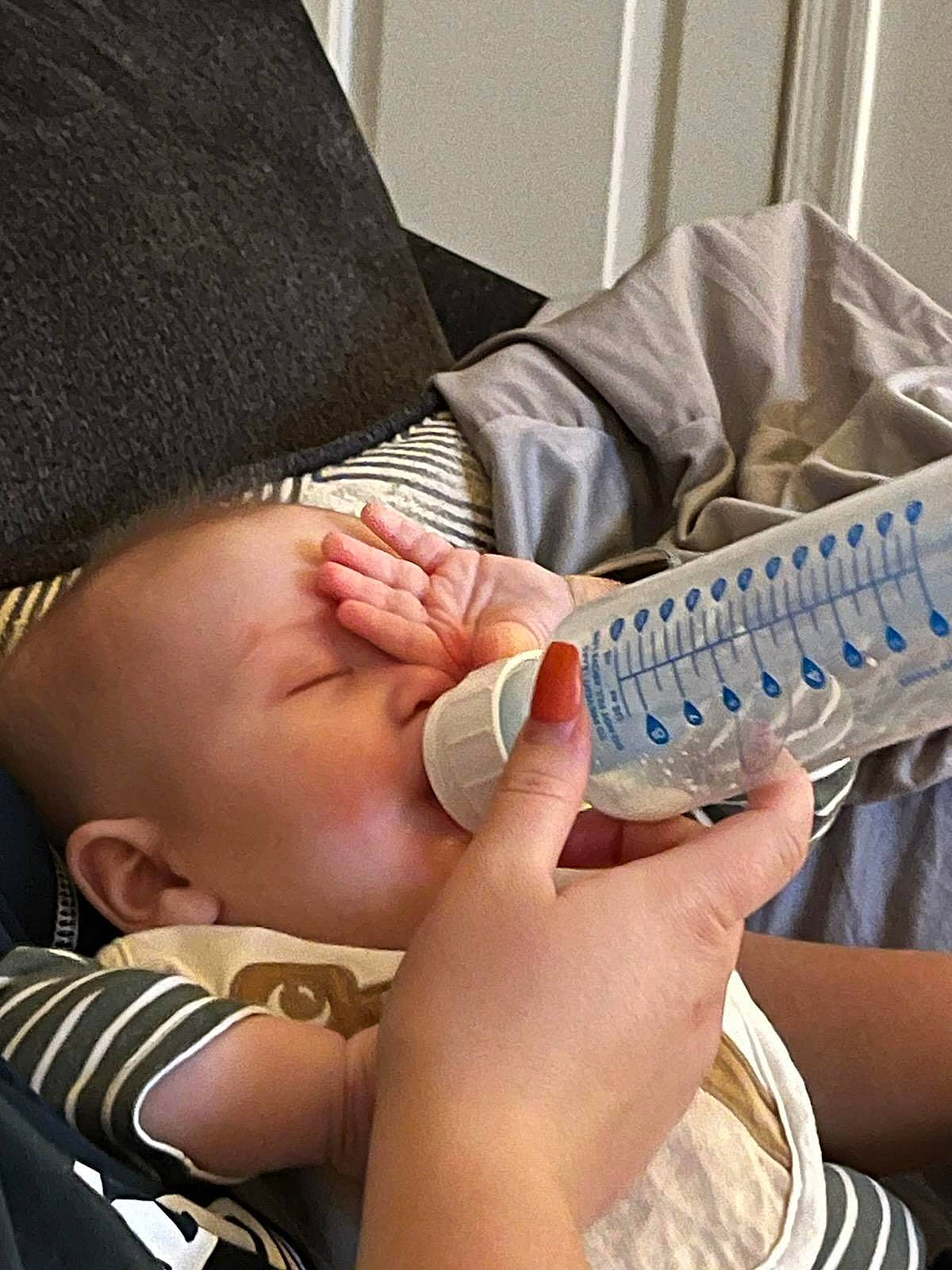 Connor is registered to the contest to win money with this photo: arm, baby, cap, child, eyelash, eyewear, finger, gesture, hand, human_leg, leg, mouth, nail, pattern, person, remote_control, sitting, tableware, thumb, toddler
