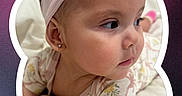 Jade joined the competition — help win amazing prizes! baby, infant, headband, bow, earrings, face, child, cute, portrait, pink, flower_frame, patterned_clothing, skin, lying_down, white_bed, closeup, young_child, expression, soft_lighting, background