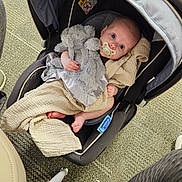 Aurora joined the competition — help win amazing prizes! baby, infant, car_seat, pacifier, blanket, stuffed_animal, plush_toy, carpet, floor, footwear, indoor, child, cute, comfort, seated, looking_up, clothing, head, skin, legs