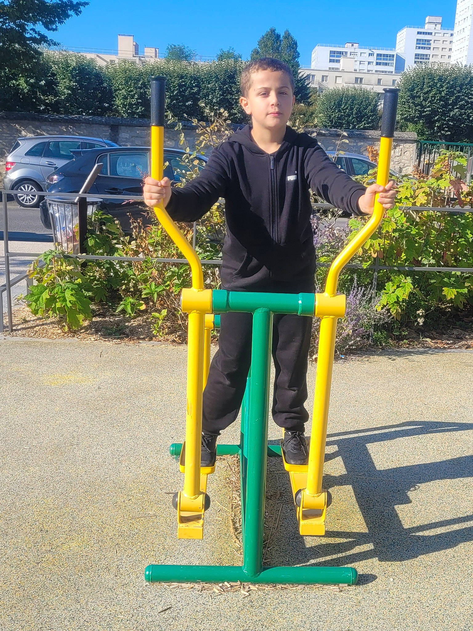 Noa participe au concours pour gagner de l'argent avec cette photo : asphalt, balance, city, electric_blue, fun, grass, leisure, outdoor_play_equipment, people_in_nature, person, plant, public_utility, recreation, road_surface, sidewalk, sky, sweatpant, t_shirt, toddler, tree